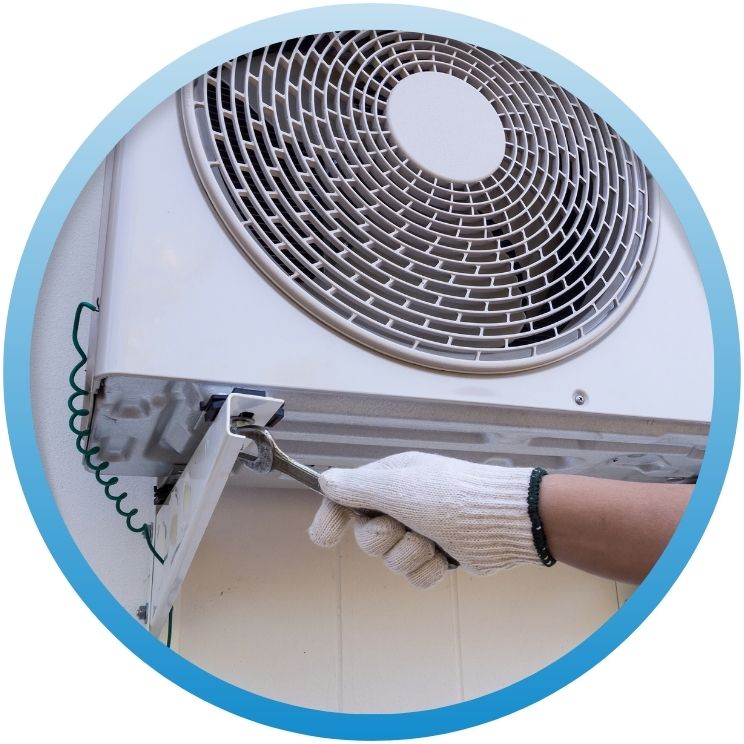 Technician using a wrench to secure a wall-mounted AC unit