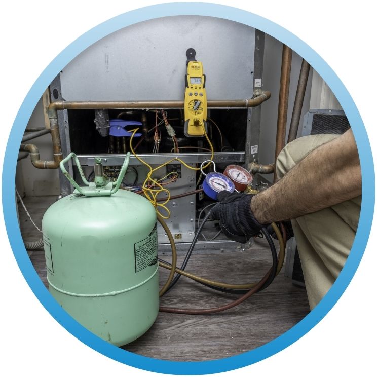 Technician checking HVAC system with refrigerant tank and gauges.