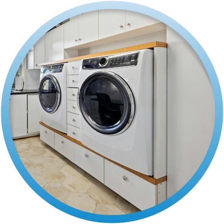 Two white modern front-load laundry machines in a laundry room.