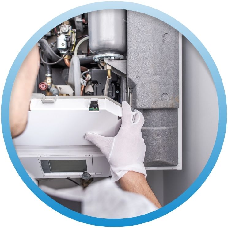 Technician in white gloves inspecting internal boiler components.