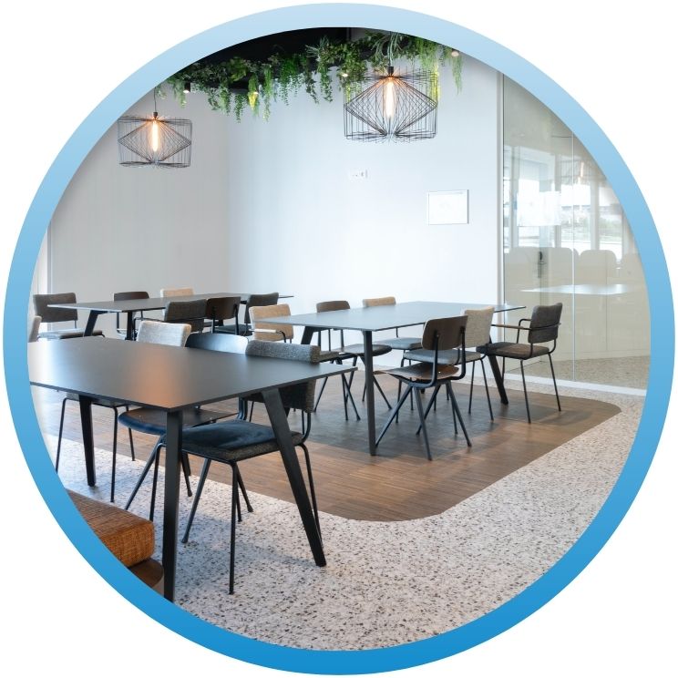Modern commercial office meeting room with tables and chairs.