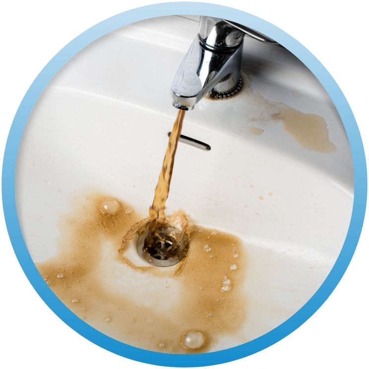 Brown, discolored water flowing from a chrome sink faucet.