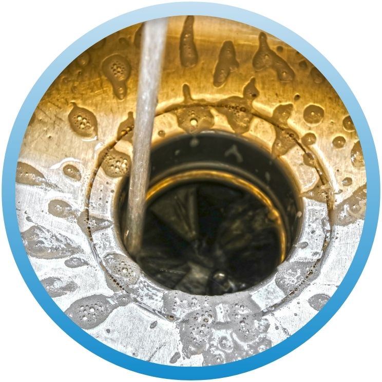 Top-down view of a running garbage disposal with soap.