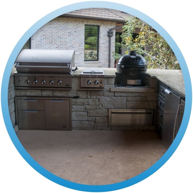 Built-in stainless steel outdoor kitchen with grill and smokers.