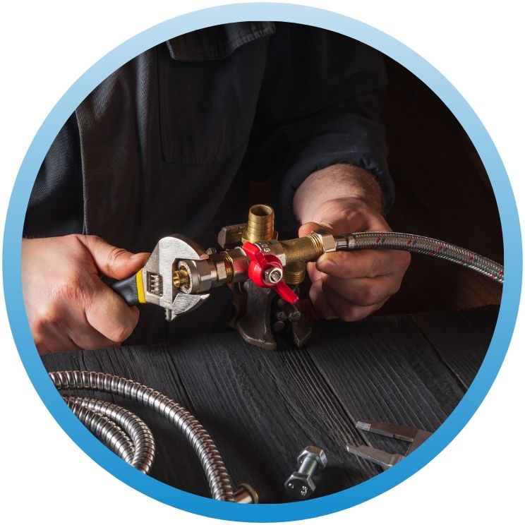 Hands using an adjustable wrench to secure a brass valve.