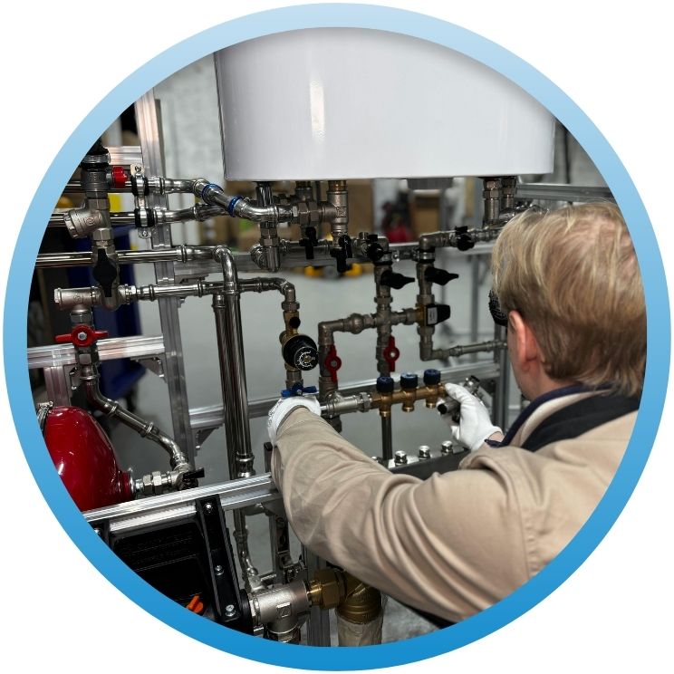 Technician inspecting a complex industrial stainless steel manifold.