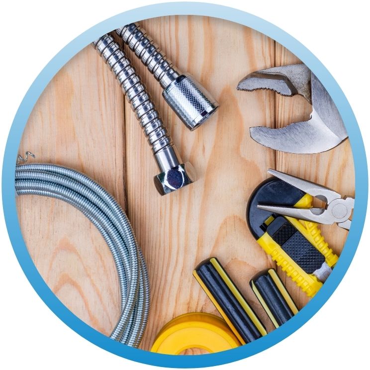 Flat lay of plumbing tools, hoses, and tape.