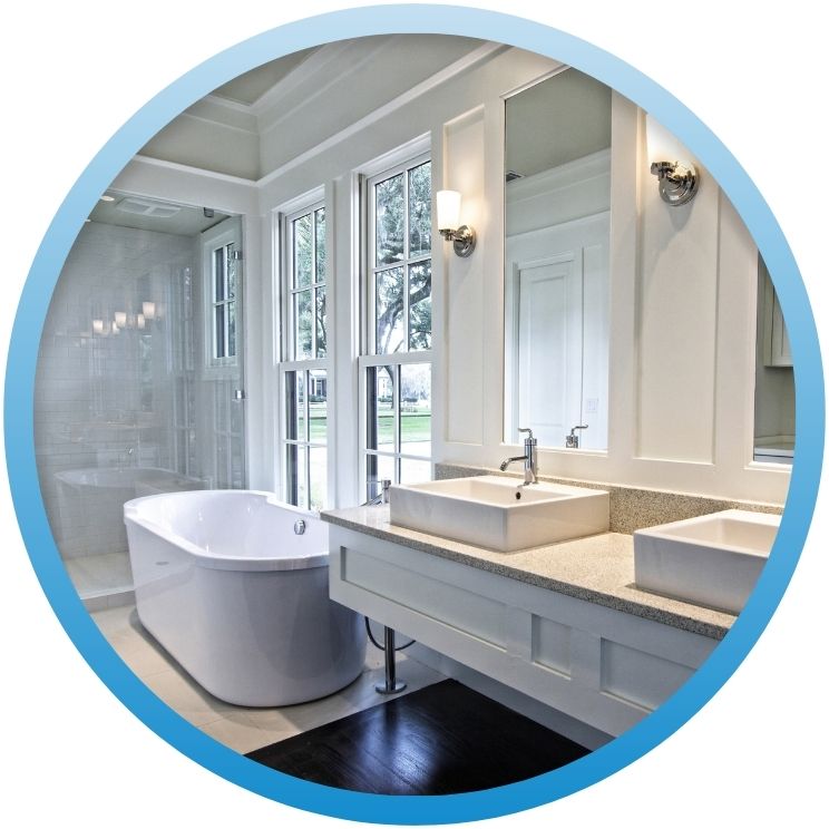 Modern white bathroom with double vanity and freestanding tub.