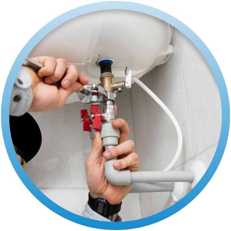 Hands using a wrench on a tankless water heater valve.