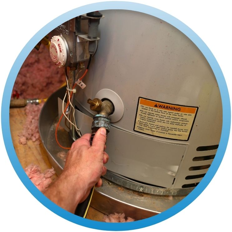 Hand connecting a drainage hose to a gas water heater.