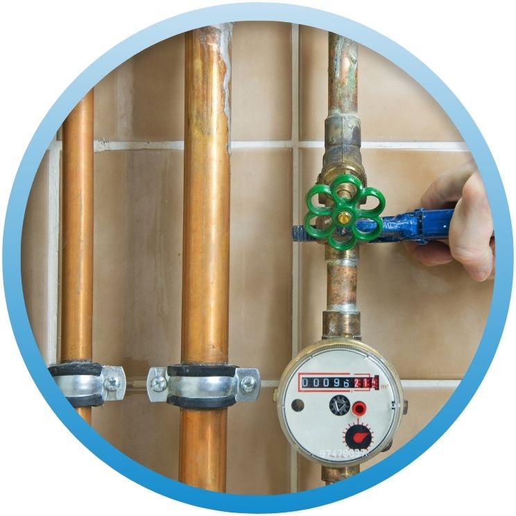 Hand using a pipe wrench to adjust a green water meter valve.