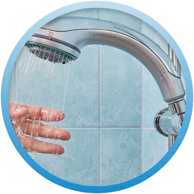 Hand testing water flow from a modern chrome showerhead.