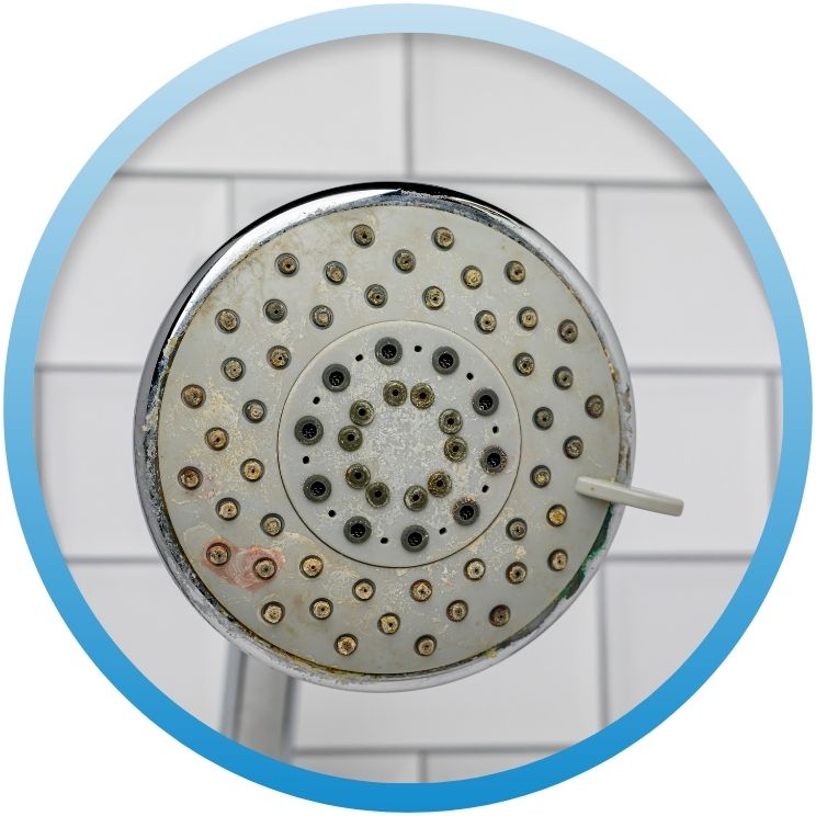 Close-up of mineral deposits on a clogged showerhead.