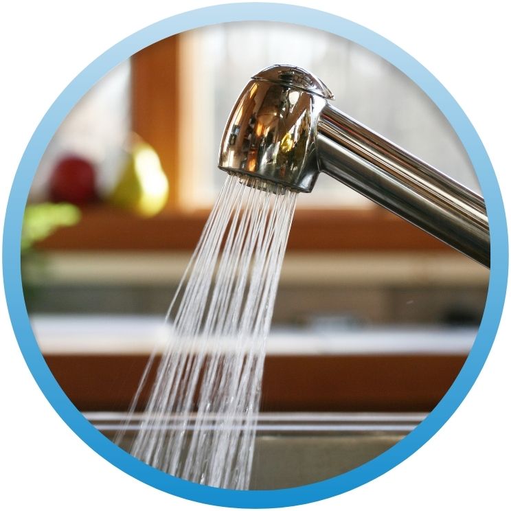 Strong water stream flowing from a chrome kitchen faucet
