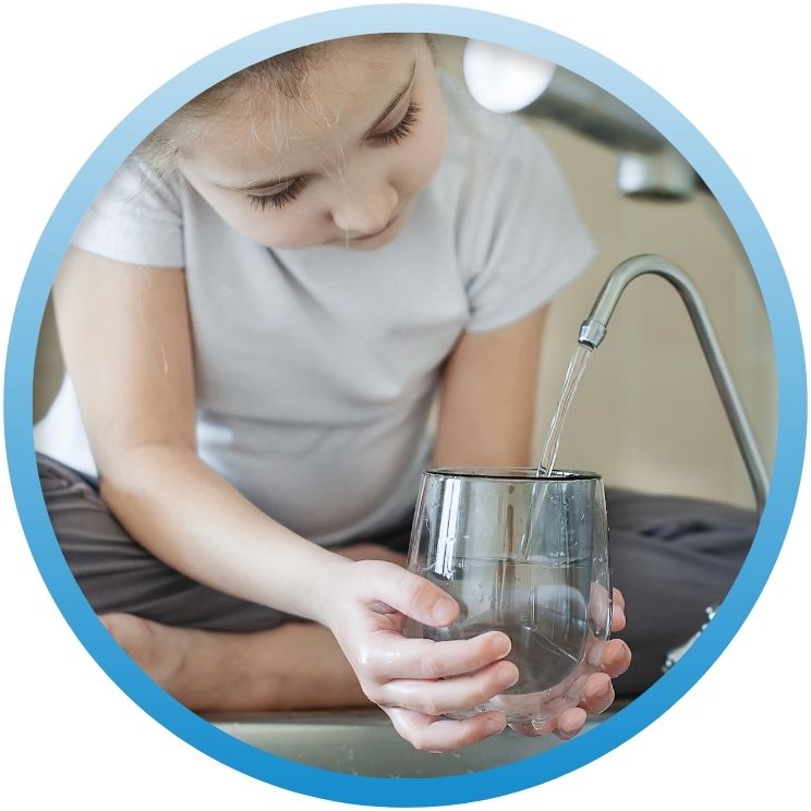 Young girl filling a glass from a filtered water tap.