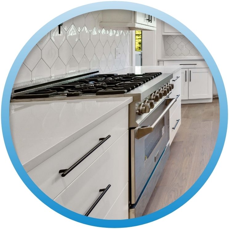 Professional stainless steel gas range in a modern white kitchen.
