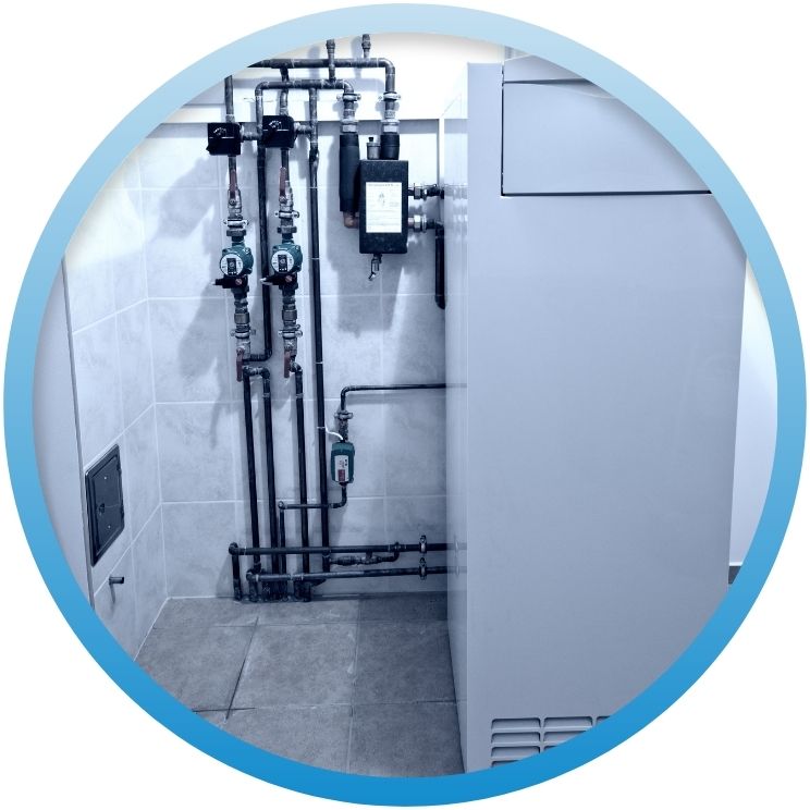 Modern mechanical room with boiler, pumps, and piping.