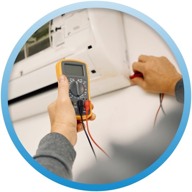 Hand using a yellow multimeter to test indoor AC.