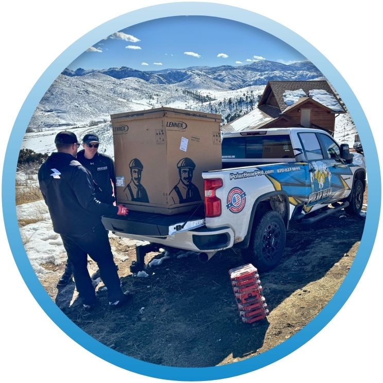 Technicians unloading a boxed Lennox unit from a truck.