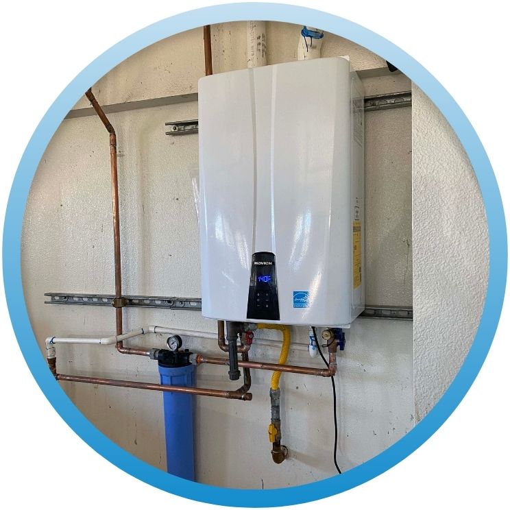 Modern white tankless water heater mounted on a garage wall.
